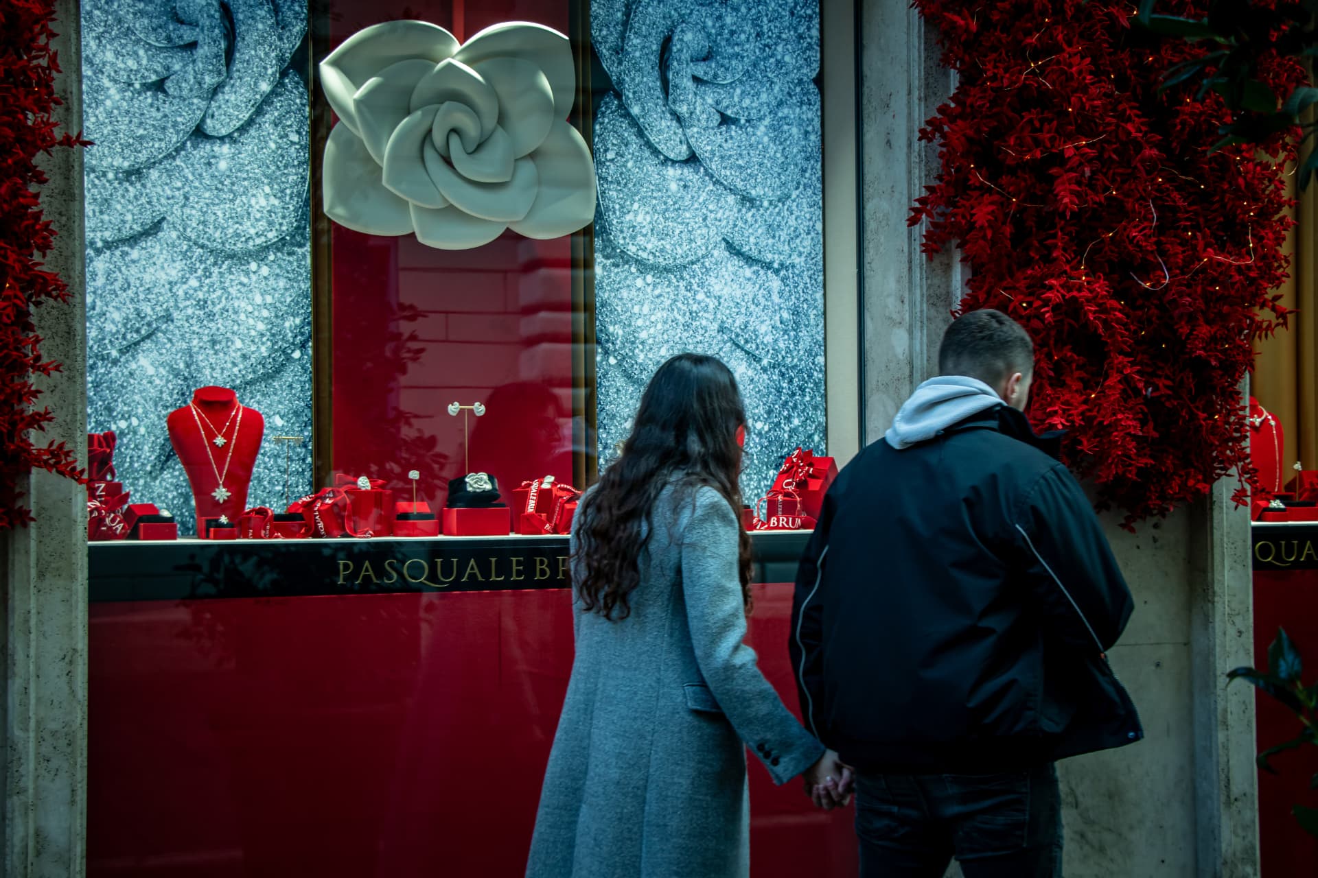 Couple before a lit shop window