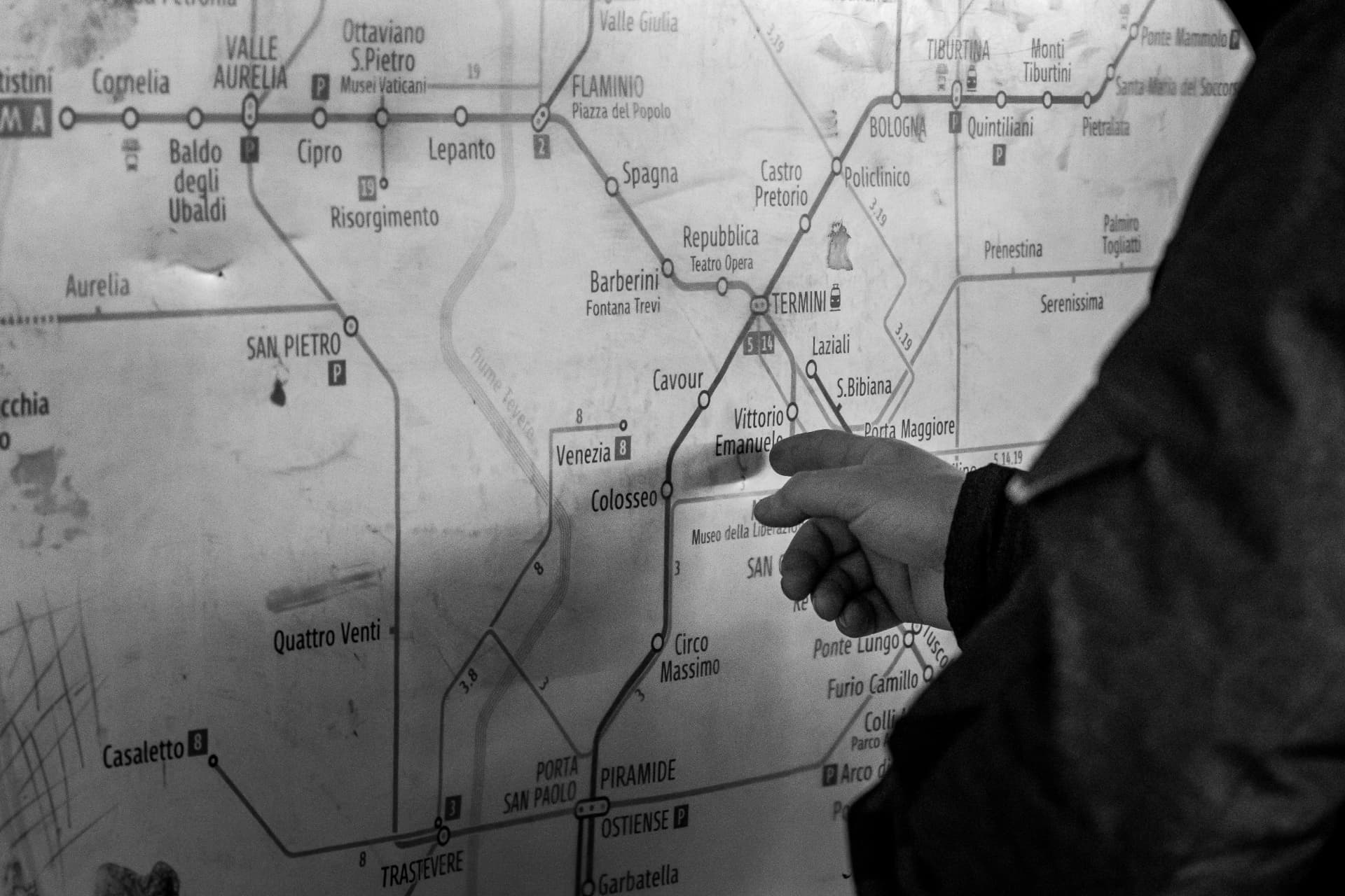 A hand pointing at the Rome metro map
