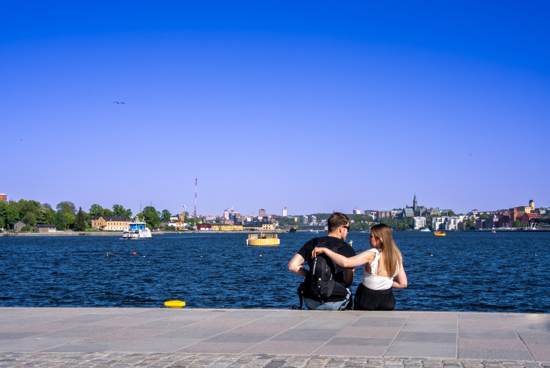 Couple on the waterfront facing the Stockholm skyline